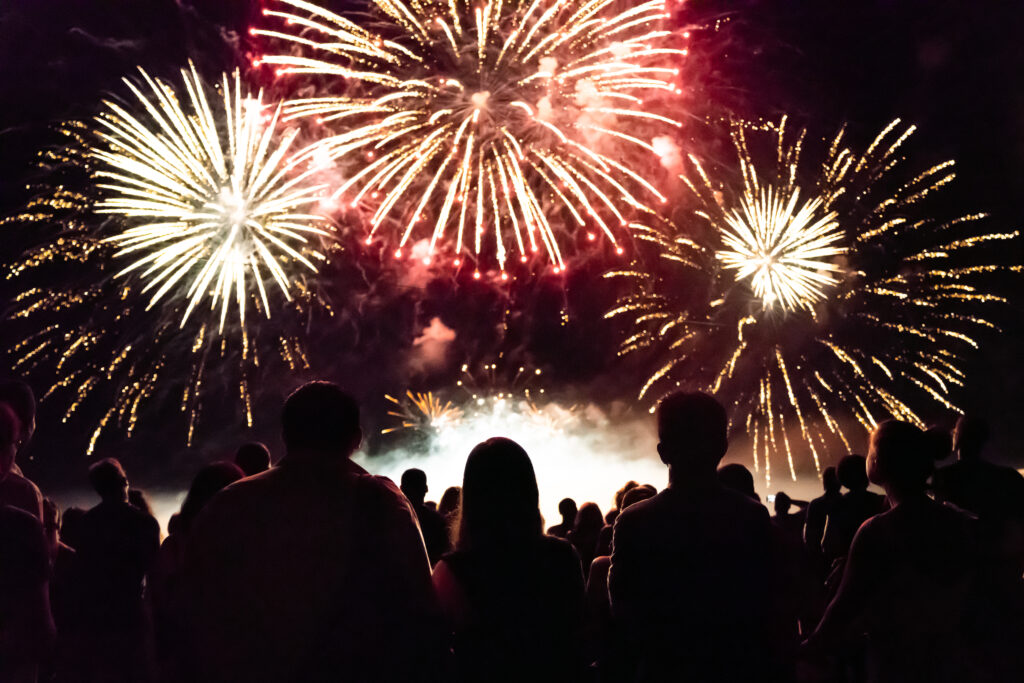 A crowd watches fireworks.